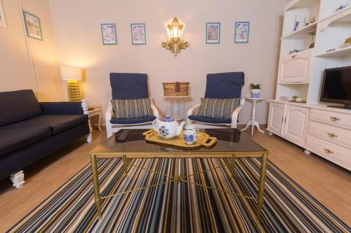 a living room with a couch and two chairs and a table at Casa da Maria in Angra do Heroísmo