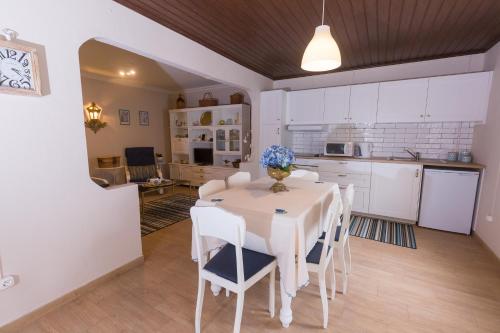 a kitchen and dining room with a white table and chairs at Casa da Maria in Angra do Heroísmo