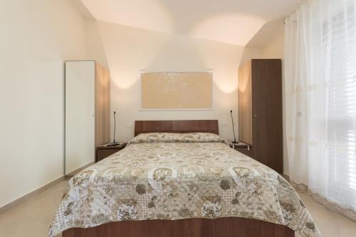 una camera da letto con un grande letto con una coperta di Incontro Montoro Guest House & Restaurant a Montoro Inferiore