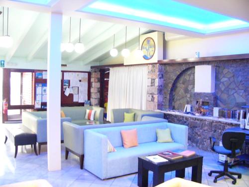 a living room with a blue couch and chairs at Blue Beach Villas Apartments in Stavros