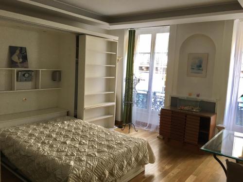 a bedroom with a bed and a dresser and a window at Eco Champs Elysees in Paris