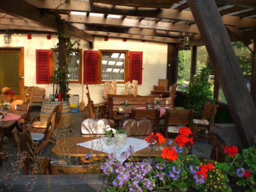 un patio con mesa, sillas y flores en Landgasthof Untere Mühle, en Alpirsbach
