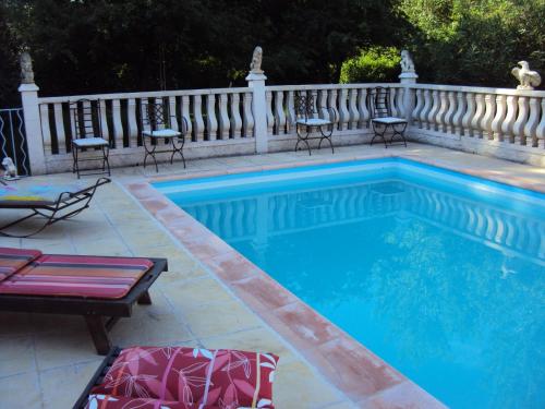 une piscine avec des chaises et une clôture dans l'établissement B&B La Douloire, à Pernes-les-Fontaines