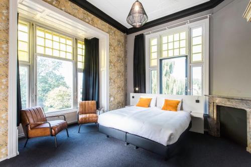 - une chambre avec un lit, une cheminée et des fenêtres dans l'établissement Rijksmonument Hotel de Sprenck, à Middelbourg