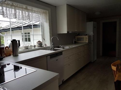 a kitchen with a sink and a microwave at Presthus Gård in Ølve