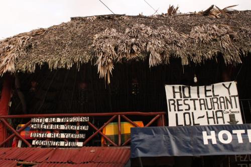 a protest sign in front of a thatched building at Hotel LOL-HA in Cobá