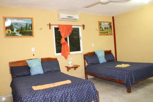 a bedroom with two beds and a window at Hotel LOL-HA in Cobá