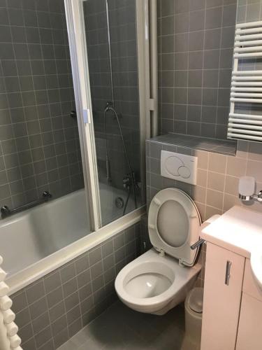 a bathroom with a toilet and a tub and a sink at Ferienwohnung Parkareal Davos in Davos