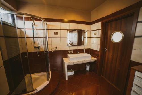 a bathroom with a sink and a glass shower at Apartamenty Blisko Centrum in Toruń