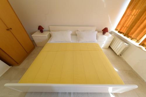 a bedroom with a large yellow bed with two pillows at Apartment Kozino 1 in Kožino