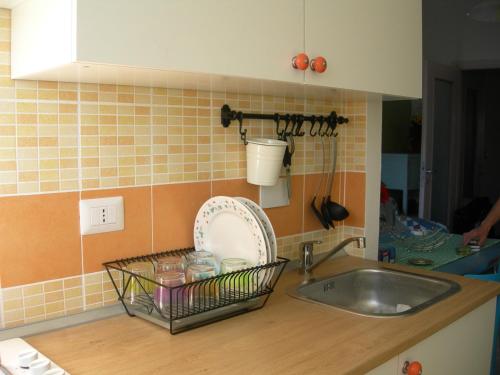 eine Küchentheke mit einer Spüle und einem Korb mit Geschirr in der Unterkunft casa gio in Turin