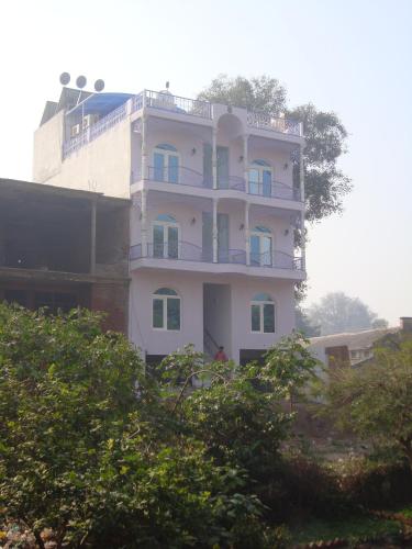 ein weißes Gebäude mit einem Balkon darauf in der Unterkunft Ray of Maya in Agra