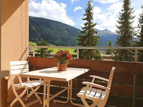 - Balcón con vistas, mesa y 2 sillas en Ferienwohnung Parkareal Davos, en Davos