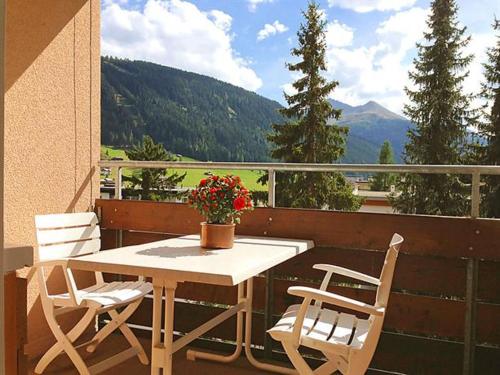 ダボスにあるFerienwohnung Parkareal Davosのテーブルと椅子2脚、景色を望むバルコニー