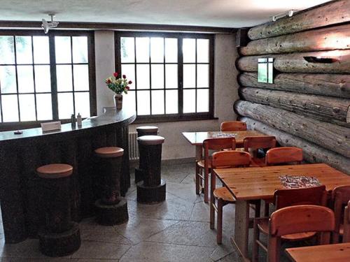 a restaurant with tables and chairs and a log wall at Ferienwohnung Parkareal Davos in Davos