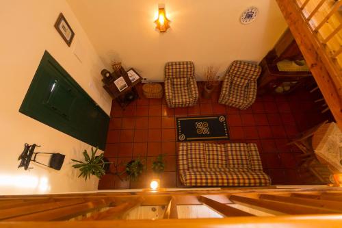 an attic room with two chairs and a table at Casa das Vinhas in Feteira