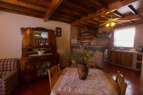 a dining room with a table and a couch at Casa das Vinhas in Feteira
