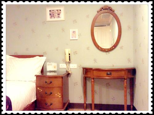 a bedroom with a bed and a mirror on the wall at Ya Tai Hotel in Nanzi