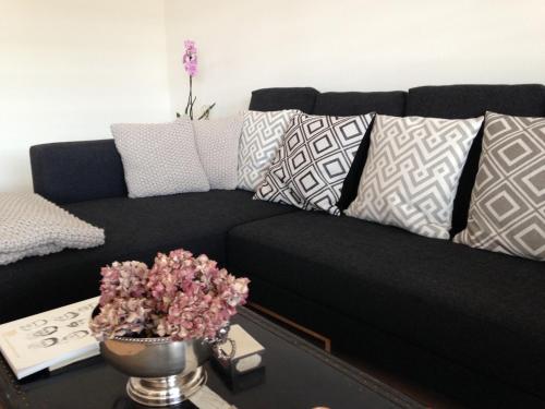 a black couch with pillows in a living room at AVLiving City INSIDE NINE Basel in Basel
