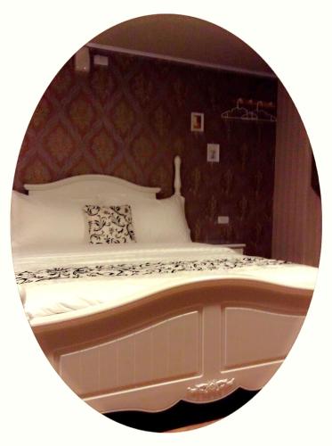 a bedroom with a bed in a round mirror at Ya Tai Hotel in Nanzi