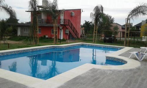 a swimming pool in front of a red house at HM San Jose in San José