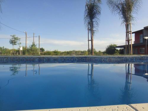 a large pool of blue water with palm trees at HM San Jose in San José