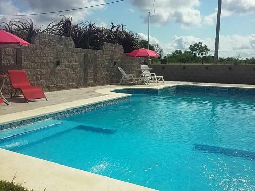 a pool with chairs and umbrellas next to a wall at HM San Jose in San José