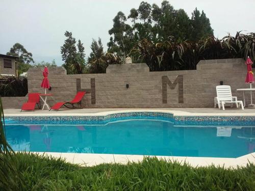 a swimming pool with two chairs and a table and chairs at HM San Jose in San José