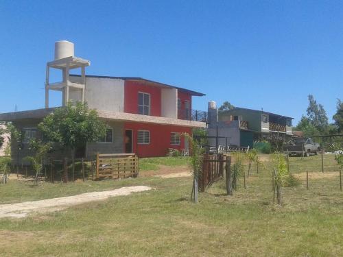 a red house with a water tower on top of it at HM San Jose in San José