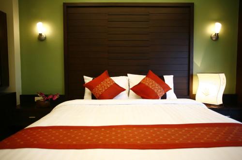 a bedroom with a large bed with red and white pillows at Lamoon Lamai Residence & Guesthouse in Lamai