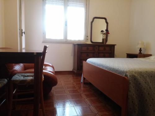 1 dormitorio con cama, mesa y espejo en Accogliente e ospitale B&B, en Perugia