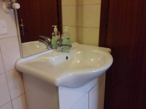 lavabo blanco en el baño con espejo en Accogliente e ospitale B&B, en Perugia