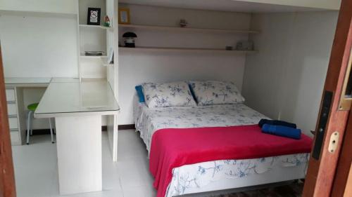 1 dormitorio pequeño con 1 cama con manta roja en Flat Manu Copacabana, en Río de Janeiro