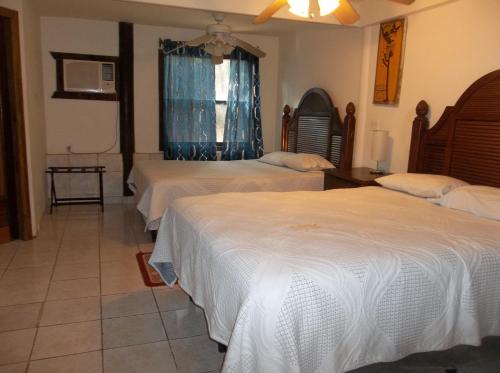 a bedroom with three beds and a window at Fosters West Bay Resort in West Bay