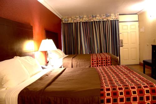 a hotel room with two beds and a window at Polynesian Inn in Saint Cloud