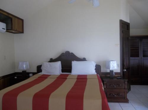 a bedroom with a large bed with a striped blanket at Fosters West Bay Resort in West Bay