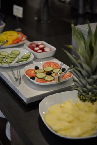 a table with plates of food and a pineapple on it at Hotell Nova in Karlstad