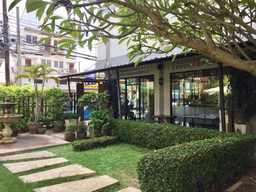 a building with a green hedge in front of it at Srisomthai Hotel in Ubon Ratchathani