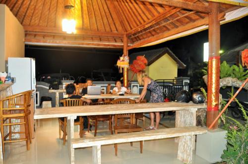 a woman sitting at a table in a restaurant at Deva Devi Beach Inn Luxury in Nusa Penida