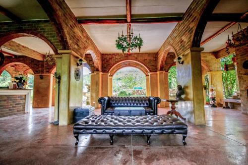 a leather couch in a room with arched windows at La Toscana in Suan Phung