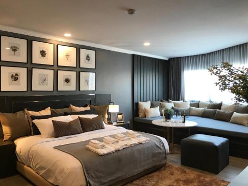 a bedroom with a large bed and a couch at Stay in Style at Nimman R306AB in Chiang Mai