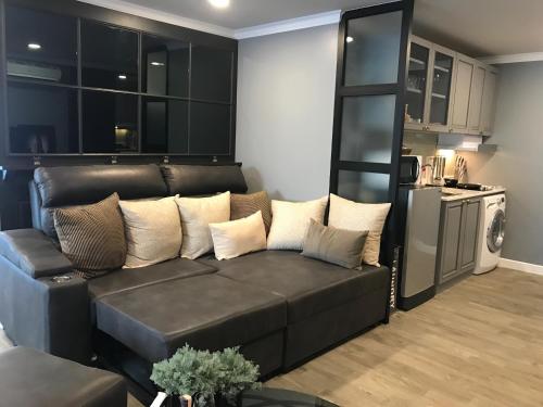 a living room with a couch and a kitchen at Stay in Style at Nimman R306AB in Chiang Mai