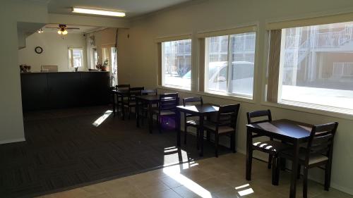 a row of tables and chairs in a room with windows at Cactus Tree Inn in Oliver