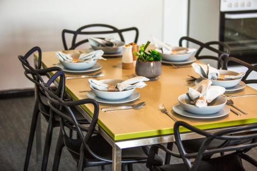 a wooden table with chairs and dishes on it at Nightcap at St Albans Hotel in St Albans