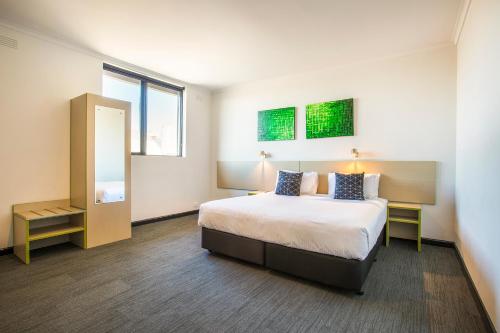 a hotel room with a bed and a mirror at Nightcap at St Albans Hotel in St Albans
