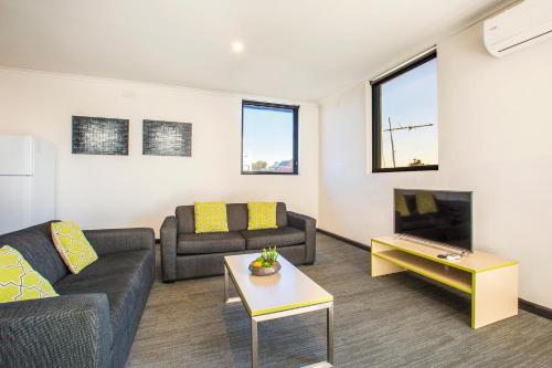 a living room with two couches and a tv at Nightcap at St Albans Hotel in St Albans