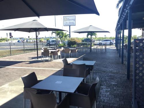 a patio area with tables, chairs and umbrellas at Kooyong Hotel in Mackay