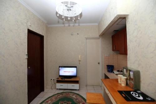 a room with a kitchen with a television on a counter at Apartemen Mediterania Garden by Netty in Jakarta