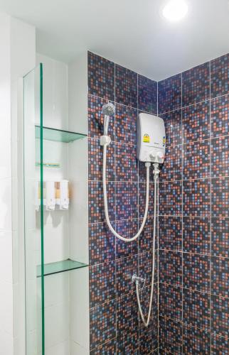 a shower in a bathroom with a tile wall at Aonang Silver Orchid Resort in Ao Nang Beach
