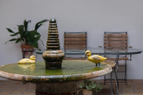 two ducks standing on a bird bath in a fountain at La Casa de Las Titas in Vélez-Málaga